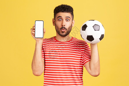 足球网站素材穿着红色T恤穿黄色背景的情绪年轻男子竞赛技术t恤玩家联盟震惊男性网络屏幕博主背景