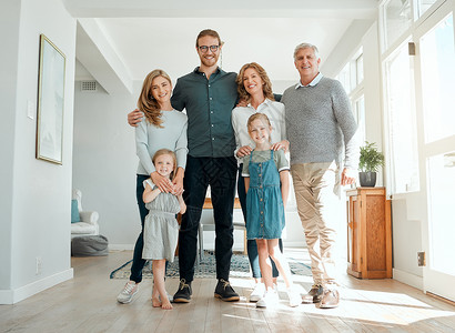 我们喜欢一家人共度时光 在家里放松的一天 一家人站在一起的全长镜头背景图片