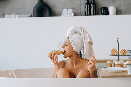 毛巾蛋糕清晨的奢华时尚女郎 在洗澡的时候吃早餐温泉身体毛巾卫生肥皂淋浴蛋糕女孩说谎面包背景
