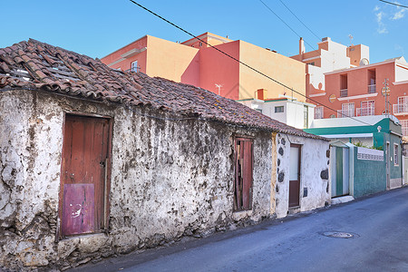 克鲁兹一个腐朽的砖瓦房的外部 在圣克鲁斯德拉帕尔马的一条狭窄街道上 一座废弃的房产或一座被风化屋顶的老式拆毁房屋的建筑背景