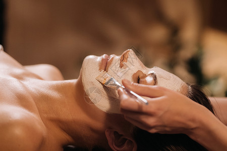 美容学家用面具遮住妇女的脸面 以恢复皮肤的活力清洁营养诊所程序奶油药品疗法打扫美容院身体病人高清图片素材