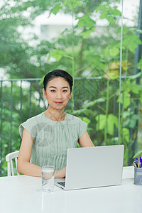 带笔记本电脑的幸福妇女明亮画面女士人士商业快乐互联网网络金融技术桌子女性背景图片