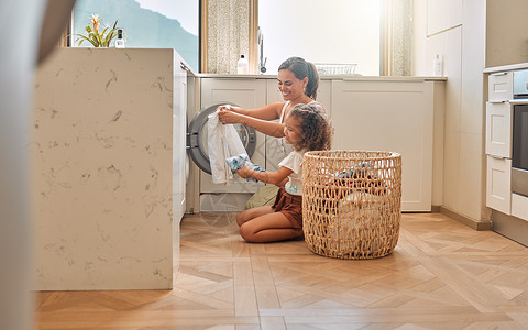提篮子小女孩年轻的西班牙裔母亲和她的女儿在家里的洗衣机里整理脏衣服 可爱的小女孩和她妈妈在家一起做家务孩子们机器幸福微笑家庭女孩成人篮子孩子背景
