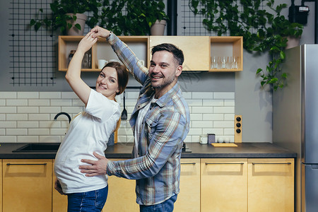 幸福的年轻家庭 期待一个孩子一起在厨房跳起舞浪漫高清图片素材