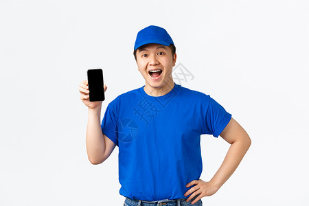 ps电话素材技术 在线购物和航运概念 穿着蓝信使制服的笑笑笑像人送货员 站着欢乐 展示移动电话屏幕 命令跟踪应用程序(PS)背景