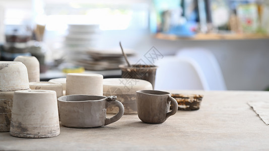 创意工作室木桌上的手工陶瓷陶器 画笔 陶器成型工具高清图片