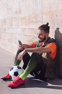 足球运动员休息时间 咨询他的手机乐趣男性享受玩家男人阅读青年互联网男生技术背景图片