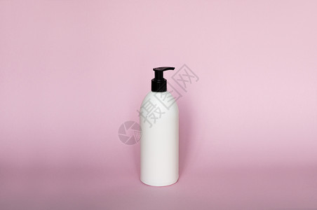 白色塑料肥皂分配器泵瓶隔离在粉红色背景上 护肤乳液 沐浴必备品 洗发水瓶 沐浴露和润肤露 精细液体手洗 浴室配件护发素包装淋浴身背景