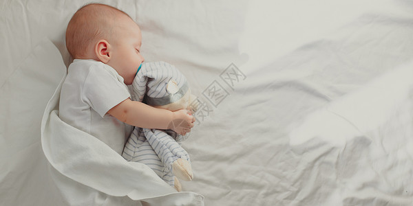 祝您好梦婴儿在他的婴儿床里睡觉 祝宝宝好梦 一个快乐的孩子 儿童用品男生按摩儿子微笑育儿乐趣家庭情感分娩皮肤背景