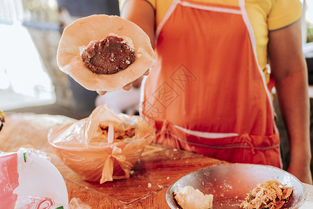 腌乳瓜供应商的手展示了传统 pupusa 的制作过程 传统 pupusas 的制作 传统尼加拉瓜 pupusas 面团的制备背景