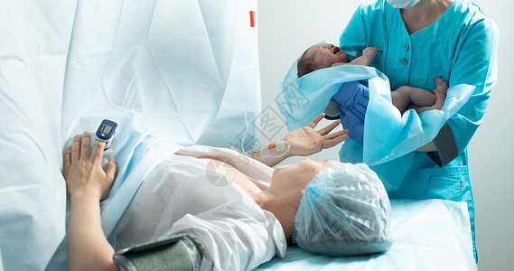 护士在医院里将新生儿与母亲亲近的婴儿抱在一起男生幸福妇科劳动孩子皮肤操作剖腹产送货疼痛手术高清图片素材