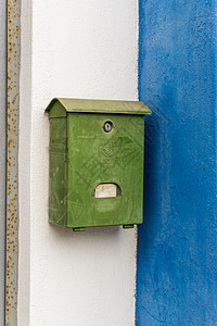 旧邮件房子白色和蓝色墙壁上的旧绿色信箱村庄邮件送货街道艺术金属邮政电子邮件乡村盒子背景
