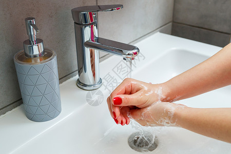 洗手关龙头浴室里有一个银色水龙头的白色水槽 灰色罐装洗手液 打开自来水 个人手卫生 在流水下洗手陶瓷温泉混合器卫生间合金龙头药品清洁度肥皂背景