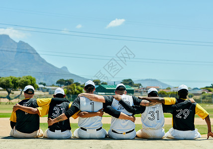 团结永远胜利 白天 一群面目全非的棒球运动员坐在棒球场附近时互相拥抱的后视镜头合身高清图片素材