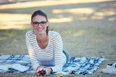 一天的休假做得正好 一个有魅力的年轻女人在公园放松的肖像背景图片