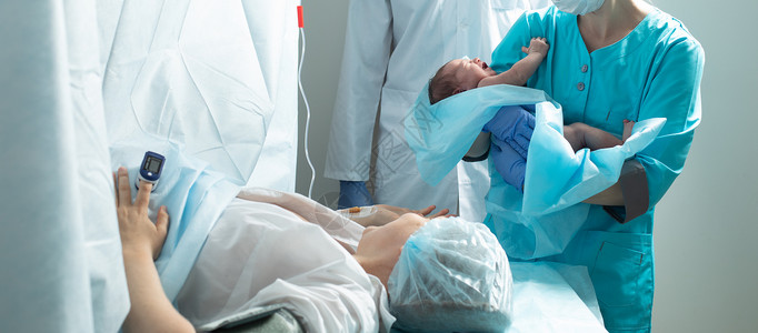 护士在医院里将新生儿与母亲亲近的婴儿抱在一起疼痛妇科医生母性男性操作妈妈孩子医生女性外科紧急情况高清图片素材