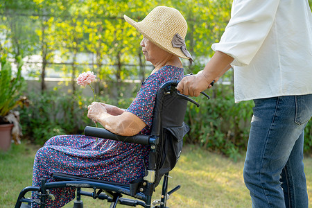 看护者帮助和照顾亚洲老年或老年老妇人病人坐在公园的轮椅上 快乐地坐在轮椅上 健康强大的医疗理念护理幸福医院卫生照顾者保健车轮椅子背景图片