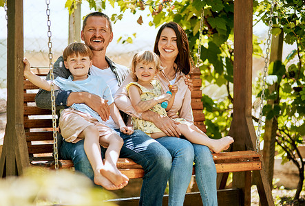 当生活赐予你家人时 珍藏他们 四人家族的肖像 在花园秋千上一起放松背景图片