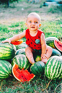 小婴儿和西瓜快乐的小男婴坐在西瓜田或花园里 快乐的婴儿微笑着 看着相机 孩子在户外吃水果 健康的生活方式概念裙子营养公园食物小吃后院卷曲乐趣背景