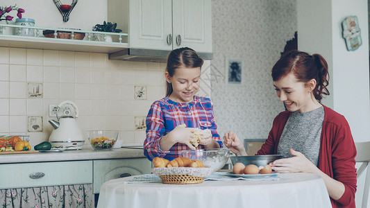 小可爱女孩在厨房帮她妈妈 赚点钱 把饼干做成碗 家庭 食物 家庭概念蛋糕高清图片素材