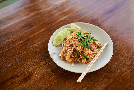 拿起你的筷子挖进去 把中国菜 放在木制桌上的盘子上高清图片