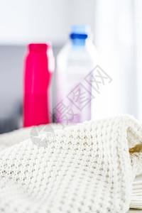面料小样温暖编织的衣服和液体洗衣洗涤剂奢华纺织品手工塑料毛衣标签服装壁橱卫生瓶子背景