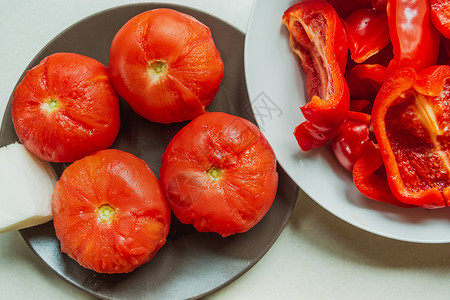 去皮番茄用红胡椒切片在盘子上煮番茄背景