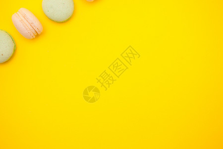 黄色背景上彩色马卡龙或马卡松的顶端视图糖果生日潮人婚礼食物小吃美食糕点杯子味道背景图片