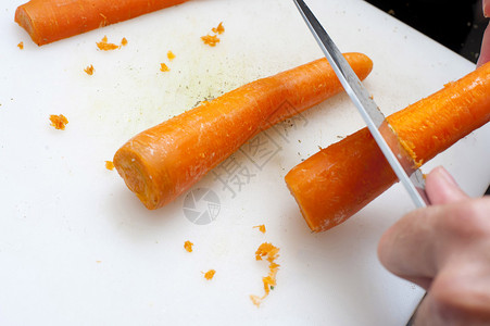 男人用刀刮胡萝卜图片