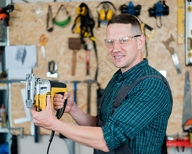 一名男子在车间用电锯锯木头的肖像工艺拼图机器手工硬木材料工作台工作男性刀刃工匠高清图片素材
