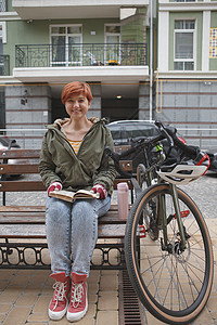 可爱的年轻女子骑自行车在城市街道上大学游客教育闲暇车辆享受越野赛运输骑术学习背景图片