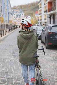 可爱的年轻女子骑自行车在城市街道上有氧运动骑术越野赛游客女士城市公路服饰女性碎石背景图片