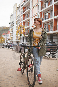 可爱的年轻女子骑自行车在城市街道上碎石有氧运动骑士越野赛骑术游客旅行运输街道城市背景图片