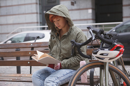 可爱的年轻女子骑自行车在城市街道上有氧运动旅行车辆学生闲暇越野赛校园教育碎石阅读背景图片