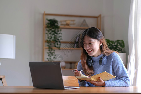 亚洲女学生在线学习班学习在线视频通话 zoom 老师 快乐的亚洲女孩用电脑笔记本电脑在线学习英语学校女性校园电话知识办公室中学图背景