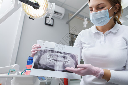 在其诊所工作的女牙科医生女性治疗x光保健扫描职业知识从业者卫生保险背景图片