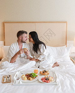一对夫妇在床上吃早餐 一对男女在卧室里 清晨吃早餐幸福食物女士女性亲热托盘微笑酒店男人杯子家高清图片素材