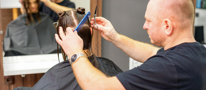 在职业美容院 男发型师剪女客户的头发工作室女孩理发发型修剪美容师剪刀成人沙龙造型师湿的高清图片素材