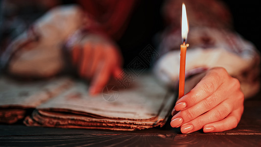 远古时代阅读古书-圣经的乌克兰妇女 烛光下 全神贯注地跟随手指在纸页上 基辅罗斯的历史 诗篇 19 世纪 祈祷文和诗篇背景