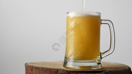 金装花纹背景啤酒被倒在啤酒杯里 装着一个把手 很多泡沫和泡沫 从玻璃中流下来酒精茶点跑步金子液体运动流动酒吧气泡溪流背景