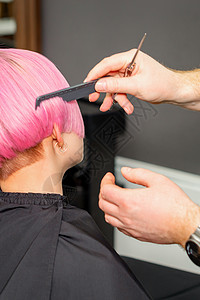 梳理头发的美发师手 在美容院里 为一位年轻的天主教女子做短粉色发型修剪梳子女孩职业美容师女性造型女士刷子沙龙客厅高清图片素材