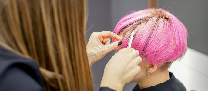 发型师准备一个年轻女子的粉红色短发 在美容院做手术头发理发师护理沙龙发型女性顾客理发成人女孩客厅高清图片素材