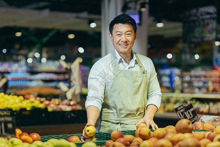 亚洲超市销售员的肖像 在杂货蔬菜区的人笑着看摄影机 看着镜头推销员高清图片素材