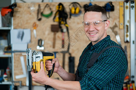 一名男子在车间用电锯锯木头的肖像锯末拼图作坊材料木工机器手工职场工具工匠木板高清图片素材