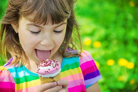 孩子吃冰淇淋 有选择的焦点乐趣女孩甜点孩子们青年奶油舌头情绪锥体牛角可口高清图片素材