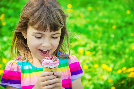 孩子吃冰淇淋 有选择的焦点巧克力婴儿女孩青年公园乐趣宏观锥体舌头微笑快乐的高清图片素材