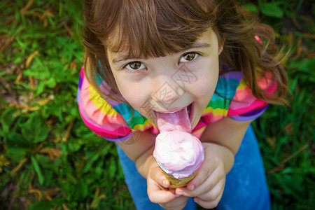 孩子吃冰淇淋 有选择的焦点舌头情绪圣代公园果汁女孩乐趣锥体甜点微笑青年高清图片素材