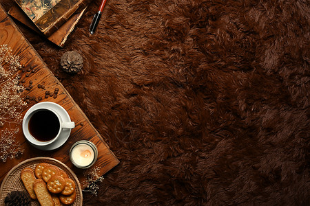 咖啡 饼干 香烛和毛绒地毯上的书背景图片