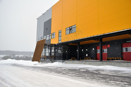 一个大型仓库的空卸货区冬季充斥着雪雨天气贮存运输商业降雪加载条件商品工业船运背景图片
