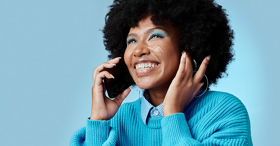黑人女性 在工作室模型中用智能手机交谈 在蓝色背景下微笑 时尚的非洲裔美国女士 拥有时尚的非洲裔 手机通话和 5g 通信网络上的蓝色的高清图片素材
